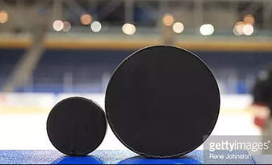 Normal Hockey Puck Next to Puck Used in Blind Hockey